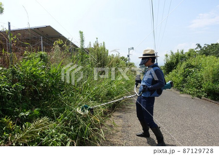 道路沿いの除草作業 草刈りをする男性 道路沿いの除草作業 草刈りをする男性 87129728