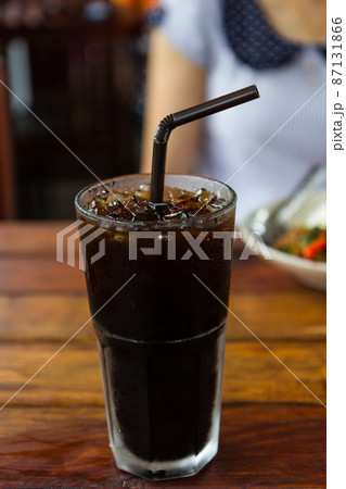 Black coffee with ice on wooden table 87131866