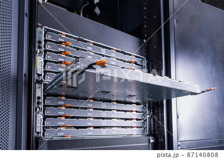 Slot for the hard drives is sticking out in the server room. Computer equipment of the Internet provider is in the data center. Hosting site with a large database. Slot for the hard drives is sticking out in the server room. Computer equipment of the Internet provider is in the data center. Hosting site with a large database. 87140808