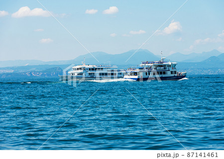Two Ferry Boats in motion on Lake Garda - Bardolino village Verona Italy Two Ferry Boats in motion on Lake Garda - Bardolino village Verona Italy 87141461