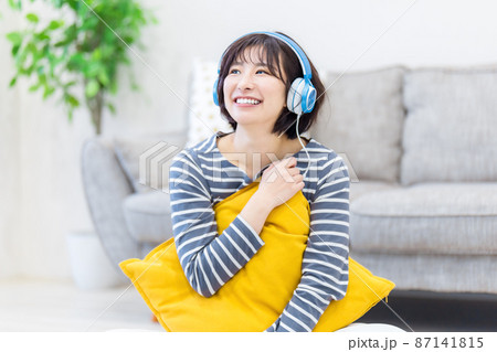 ヘッドフォンで音楽を聴く若い女性 87141815