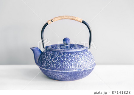 Blue cast iron teapot on a white background. Blue cast iron teapot on a white background. 87141828