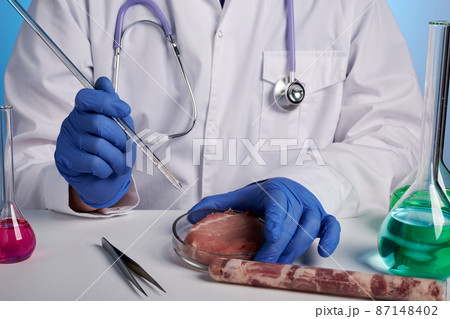 Doctor Tests Artificial Meat in Petri Dish with Glass Stick Doctor Tests Artificial Meat in Petri Dish with Glass Stick 87148402