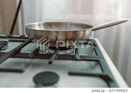 Frying pan on white gag stove in kitchen. Cooking. 87149682