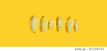 Flat lay composition with fresh organic vegetable marrow on yellow color background. Top view. Flat lay pattern, banner. Flat lay composition with fresh organic vegetable marrow on yellow color background. Top view. Flat lay pattern, banner. 87149742