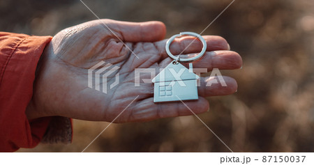 Giving house keychain, choosing best house insurance, making right decision on home investment concept 87150037