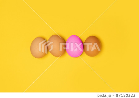 Tasty brown chicken eggs and one broken egg with yolk on yellow background Tasty brown chicken eggs and one broken egg with yolk on yellow background 87150222