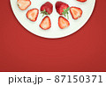 Top view of strawberry in a half plate on isolated red background with copy space 87150371