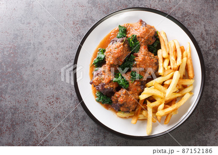 Tasty Rabo de toro or oxtail stew served with french fries on white plate on the table. Horizontal top view 87152186