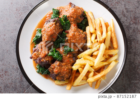 Oxtail in sauce Rabo de toro served with french fries on white plate on the concrete table. Horizontal top view 87152187