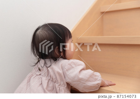 フローリングの階段を登ろうとする0歳の赤ちゃんの女の子 フローリングの階段を登ろうとする0歳の赤ちゃんの女の子 87154073