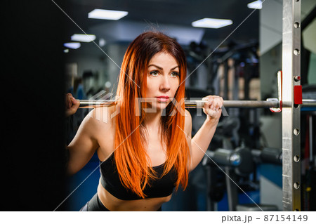 Woman exercise with lifting weights in gym 87154149