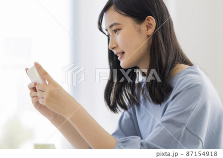 スマホを見ながら勉強をする女の子 高校生 中学生 スマホを見ながら勉強をする女の子 高校生 中学生 87154918