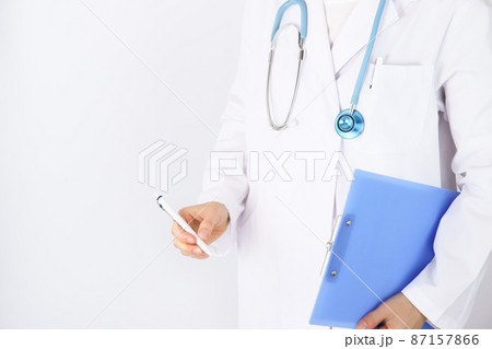 バインダーを持つ 白衣の医師 臨床研修医 白背景 水色の聴診器 バインダーを持つ 白衣の医師 臨床研修医 白背景 水色の聴診器 87157866
