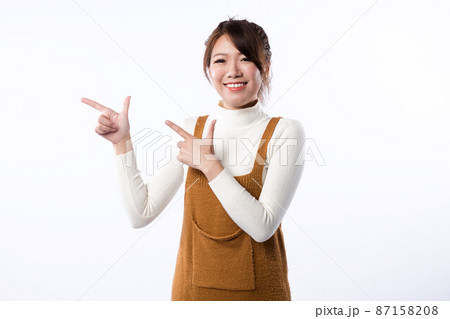 A smiling young girl demonstrate something isolated on white background. 87158208