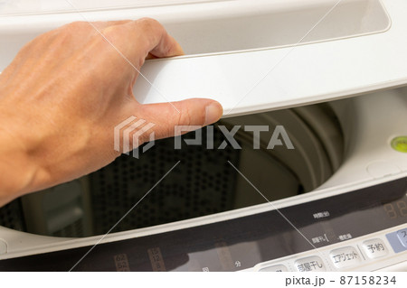 洗濯機の蓋を手で開ける 87158234
