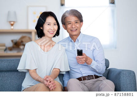 リモコンを持ってテレビを見るシニア夫婦 リモコンを持ってテレビを見るシニア夫婦 87158801