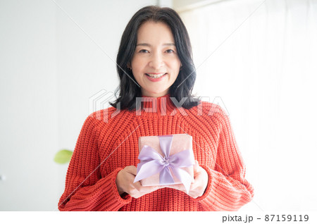 プレゼントを抱える美しいアジア人（日本人）の女性 クローズアップ　カメラ目線 コピースペースあり 87159119