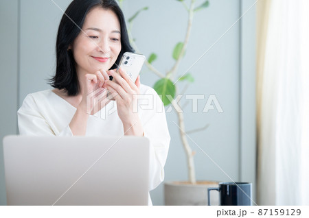 スマホでタップする見る美しい日本人女性のズーム　コピースペースあり 87159129