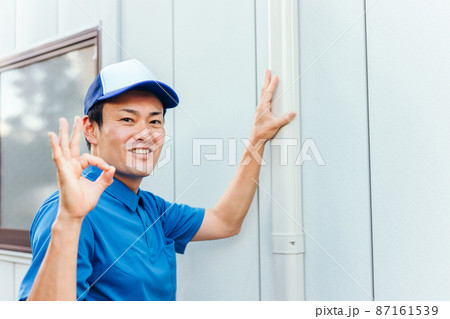 エアコンの配管化粧カバーと作業着の男性 87161539