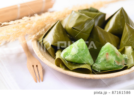 Thai dessert (Khanom Tian), Sweet dough pyramid stuffed with coconut wrapped by banana leaf Thai dessert (Khanom Tian), Sweet dough pyramid stuffed with coconut wrapped by banana leaf 87161586
