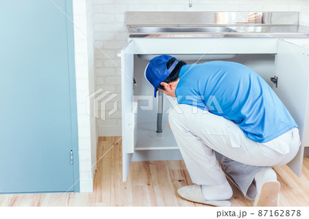 シンクを掃除する作業着の男性 87162878