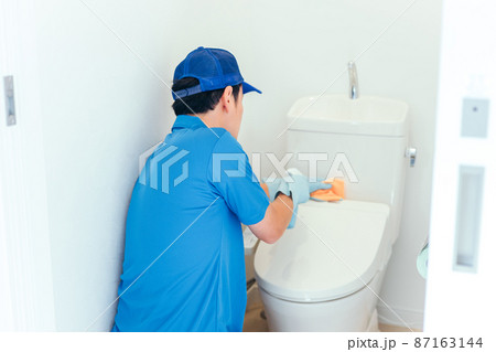 トイレの掃除をする作業着の男性 87163144