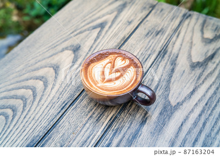 Hot latte art coffee in ceramic cup on wooden table Hot latte art coffee in ceramic cup on wooden table 87163204