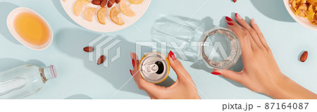 Dried fruits and nuts with sauce on blue background with womans hands 87164087