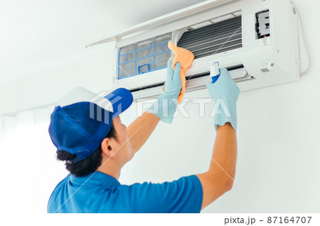 エアコン・空調設備の清掃をする作業着の男性（洗剤） 87164707