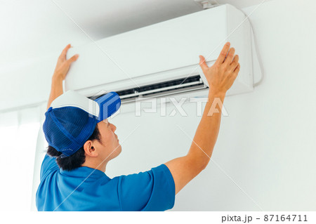エアコン・空調設備のチェックをする作業着の男性 87164711