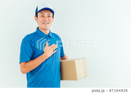 段ボールを持った作業着の男性 87164926