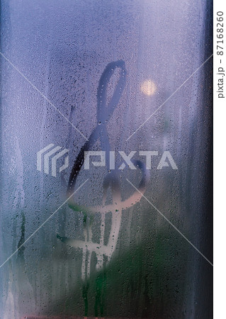 G-clef drawing on window isolated on blue background. 87168260