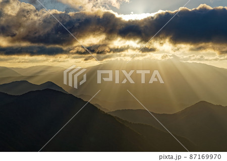 谷川岳・西黒尾根の登りから見る朝日差す山並み 87169970
