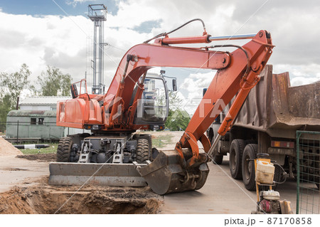 Excavation Works Industry. Industrial Heavy Machines Digging Equipment Dump Truck on Construction Site Excavation Works Industry. Industrial Heavy Machines Digging Equipment Dump Truck on Construction Site 87170858