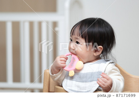 歯固めのオモチャで遊ぶ生後10ヶ月の赤ちゃん 87171699