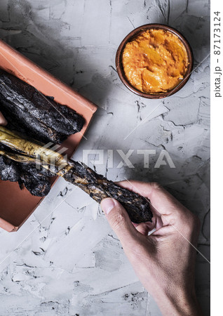man about to eat calcots, catalan sweet onions 87173124