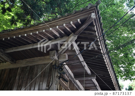 電線が通っている歴史のある社を見上げている風景 87173137
