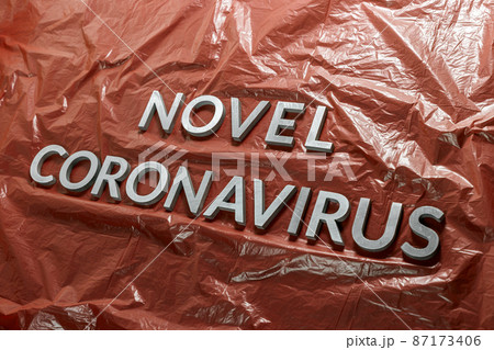 Words novel coronavirus laid with silver letters on emergency red crumpled plastic film backdrop in diagonal composition Words novel coronavirus laid with silver letters on emergency red crumpled plastic film backdrop in diagonal composition 87173406