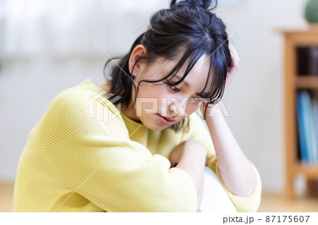 膝を抱えてしゃがみこむ女性 ネガティブイメージ 87175607
