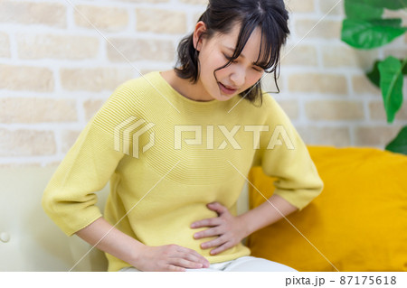 お腹を押さえて苦しむ女性 ネガティブイメージ お腹を押さえて苦しむ女性 ネガティブイメージ 87175618