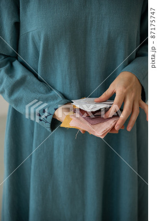 Woman holding prices of colourful linen tissue examples. Woman holding prices of colourful linen tissue examples. 87175747