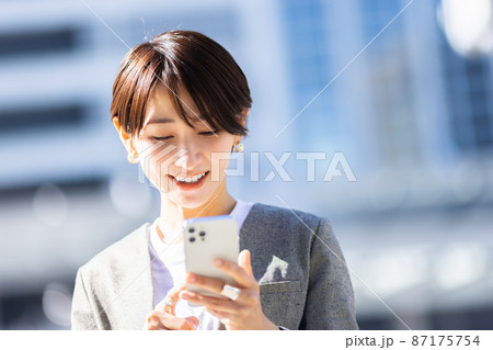 街中でスマホを操作する女性 87175754
