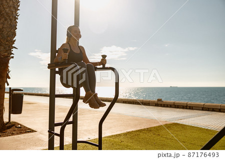 Young athletic woman exercising at city park 87176493