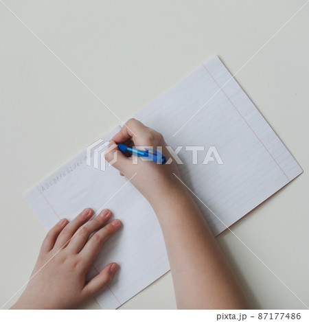 pupil's hands writing in open notebook, top view, copy space pupil's hands writing in open notebook, top view, copy space 87177486
