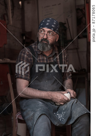 Spoon craft master in his workshop with handmade wooden products and tools working  87178065