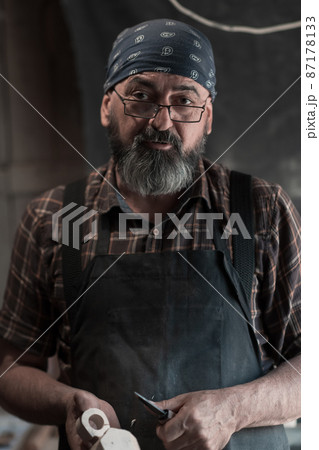 Spoon master in his workshop with wooden products and tools Spoon master in his workshop with wooden products and tools 87178133