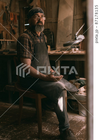Spoon master in his workshop with wooden products and tools 87178135