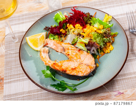 Salmon steak with salad served on plate 87179867