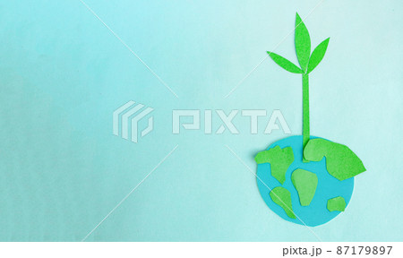 Cute children's paper applique -a model of the Earth and a young sprout on a blue background. Creative concept Earth Day, Earth Hour, copy space for text 87179897